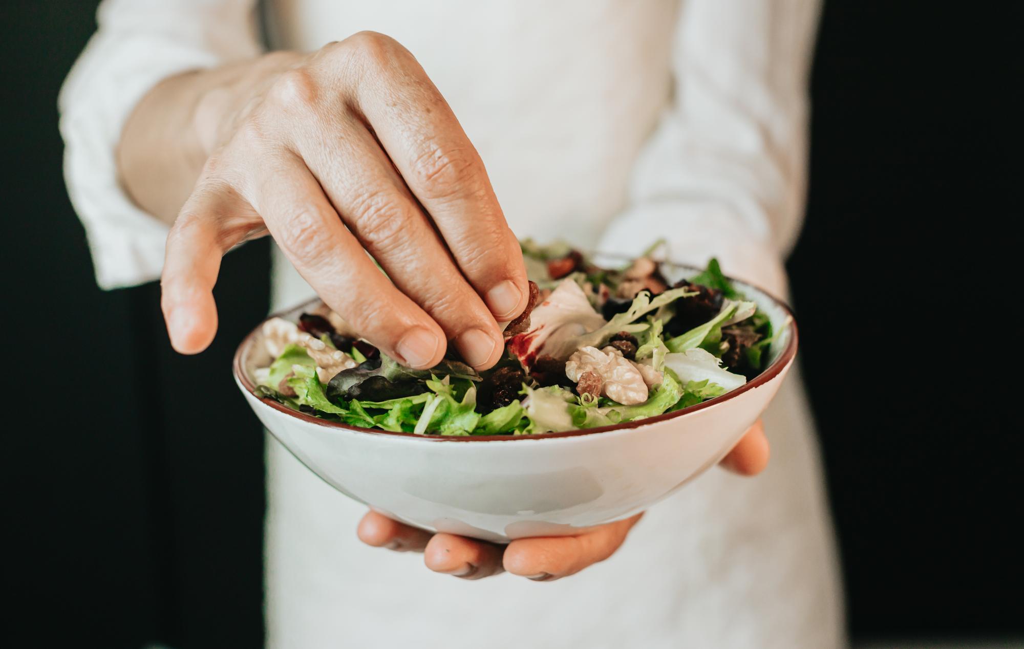 Chef hands garnishing salad